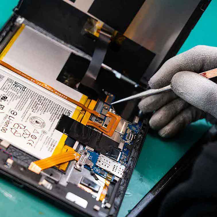 Medarbejder fra OnSpotRepair fra Hvidovre, er i gang med at reparerer en tablet.  